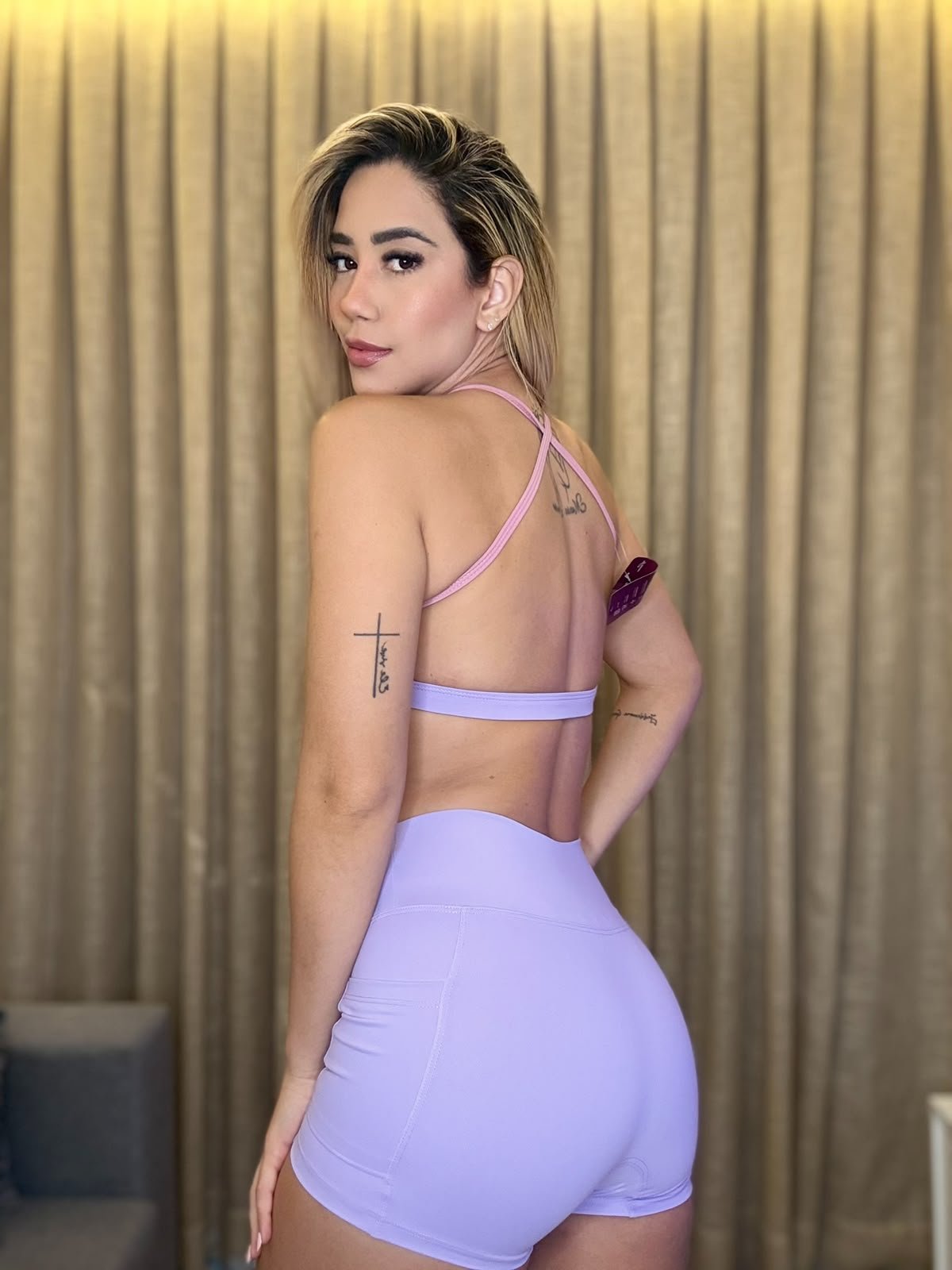Cliente Hello Fitness usando top lilás, vista das costas